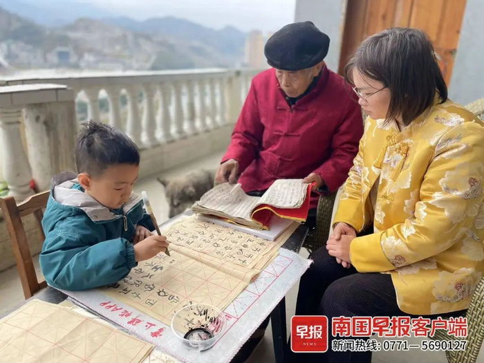 ▲罗爱香和儿子一起向伯祖父谢朝海学习水书。