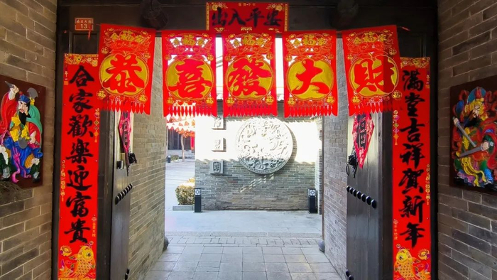 忻州古城里的一处旧式门坊,上边对联,横批,福字,掉钱和门神一应俱