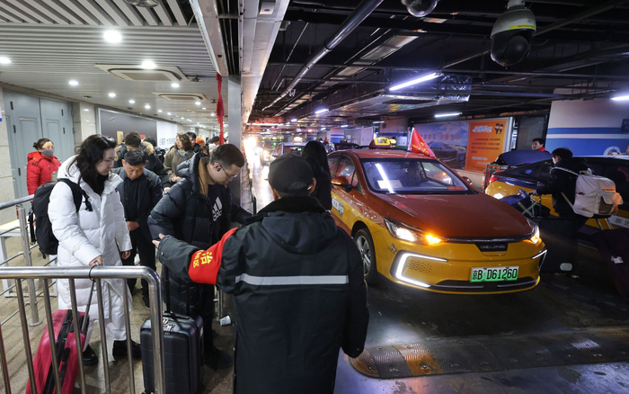 工作人员正引导旅客抓紧时间上车。新京报记者 王贵彬 摄