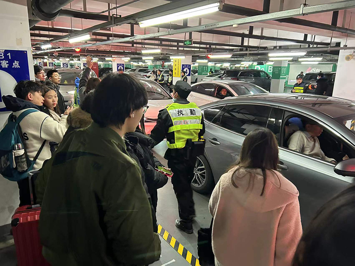 2月17日晚上，上海虹桥火车站P9停车场，民警王剑和同事在疏导车辆，引导旅客乘车。