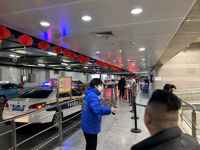 2月17日晚上21时许，上海虹桥火车站，南2出租车上客点，许多旅客在此排队打车，工作人员维护秩序。