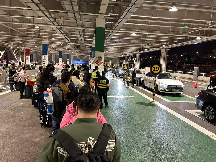 2月17日晚上，上海虹桥火车站，2024年新开辟的P9地面停车场有22个上客点，乘客排队打车乘车。