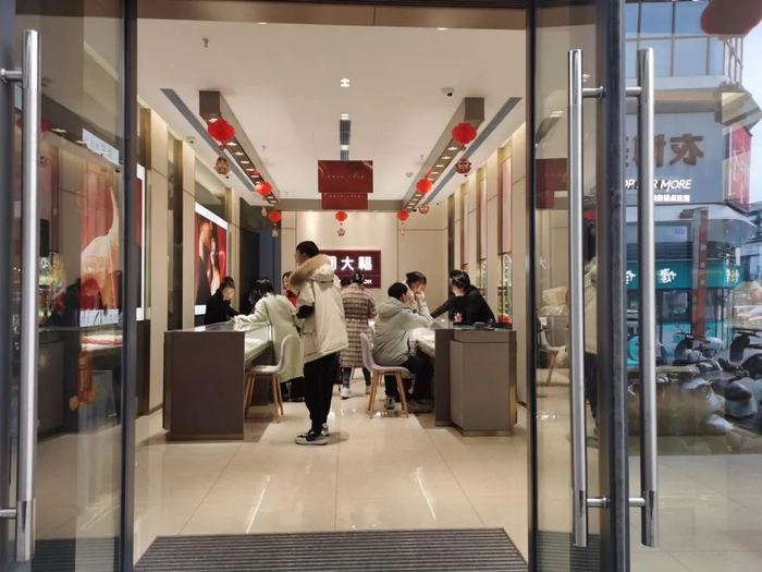 四川省东南部某县城一家周大福加盟店内，消费者正在试戴首饰，摄于2月15日16时左右