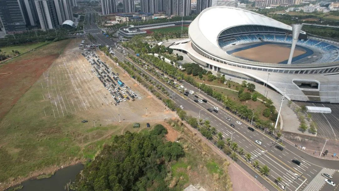 海口新海港乘坐渡轮过海的车辆在五源河体育场停车场处等待进港。图 / 视觉中国