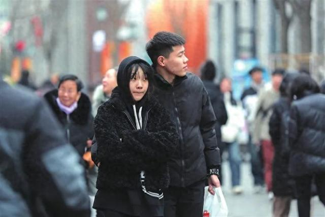 受冷空气影响,2月19日,全市出现大风降温天气,仍有众多市民在柳巷