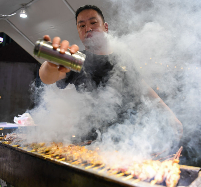 商户在南京市建邺区西城·夜未央街区内制作特色烧烤 李博/摄