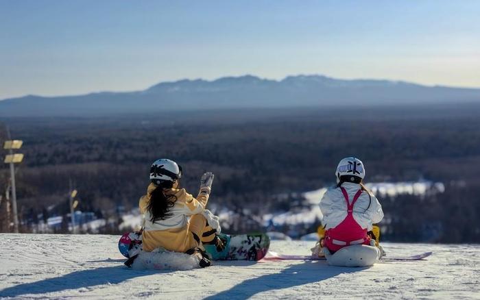 ▲2月2日，雪友在长白山和平滑雪场的媒体们雪坡上远眺长白山主峰。图/新华社