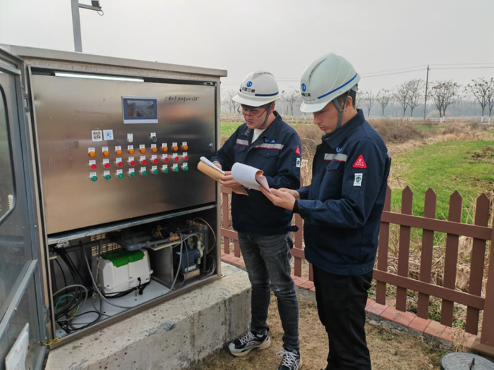 ▲陈正雷（左）与同事在现场检查设备情况。 摄影：邹洁