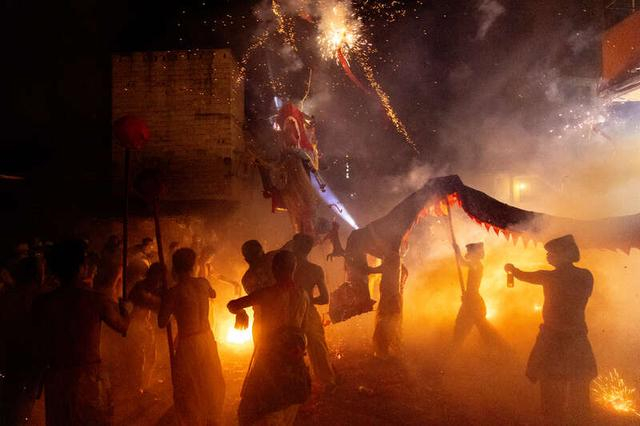 2月20日晚，广西壮族自治区南宁市宾阳县炮龙老庙附近，人们纷纷将手上的鞭炮投向舞动的炮龙，祈求吉祥好运。江畅/摄
