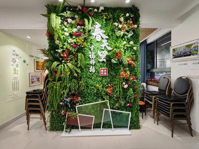 走进活动室,郁郁葱葱,花团锦簇的"春天里·幸福驿站"文化墙映入眼帘