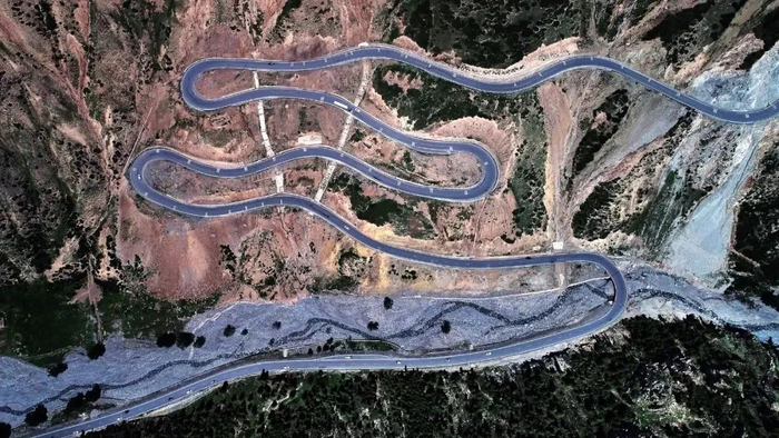 独库公路宛如一条巨龙盘卧天山，蜿蜒着通向山巅（资料图片）。李浩然 摄