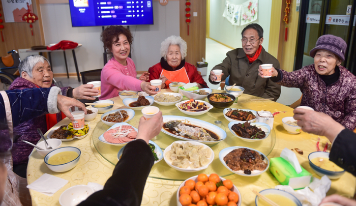 ▲老人及家属在一起吃“团圆饭”。图/新华社