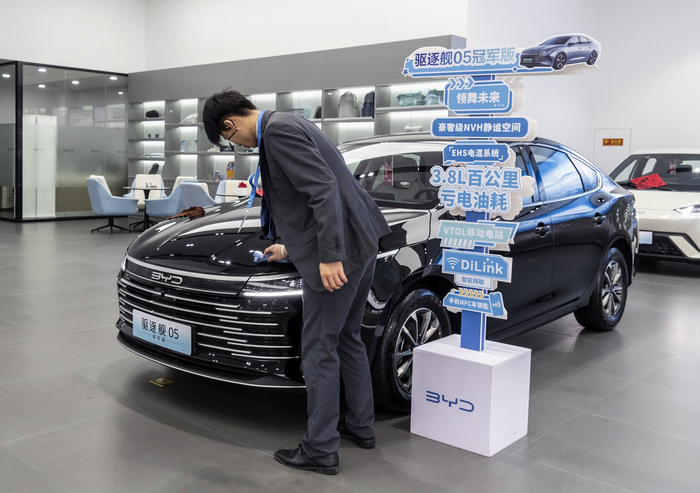 2024年1月17日，深圳，一名员工在展厅内擦拭比亚迪驱逐舰05插电式混合动力汽车。
