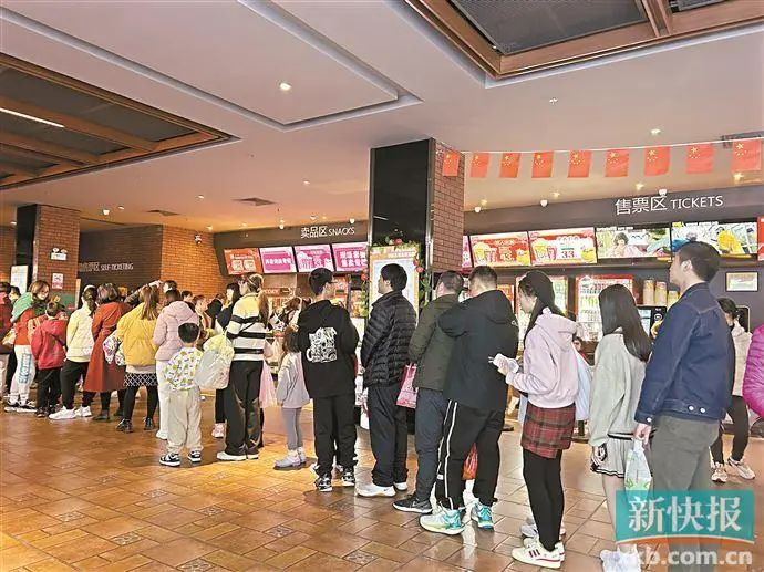 ▲今年贺岁档异常火爆，广州一家影院检票排长龙。