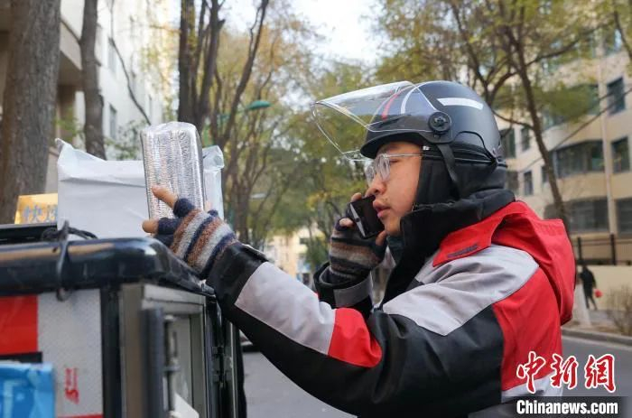 图为快递小哥正在派送快递。马铭言 摄