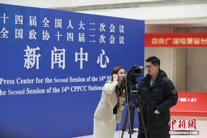 图为香港媒体记者在全国两会新闻中心采访拍摄。 蒋启明 摄