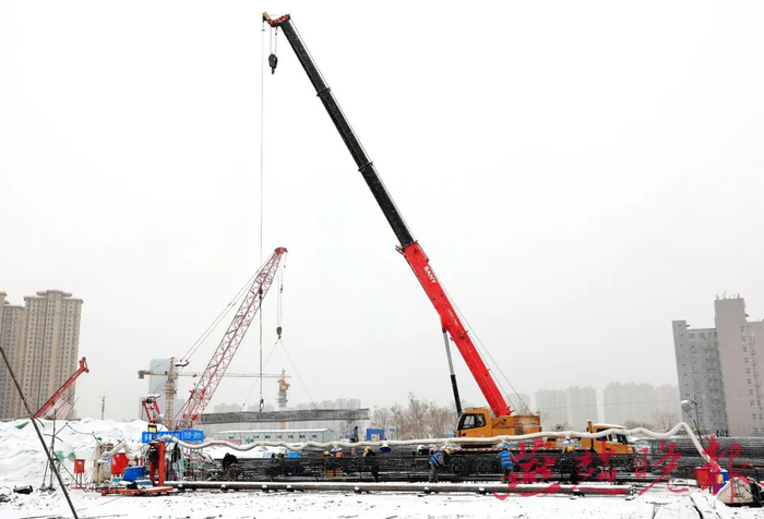 建设者在雪中奋战，加快高铁片区57号地块超高层地标建筑项目建设速度。