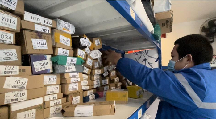 菜鸟驿站里的快递员在整理快件