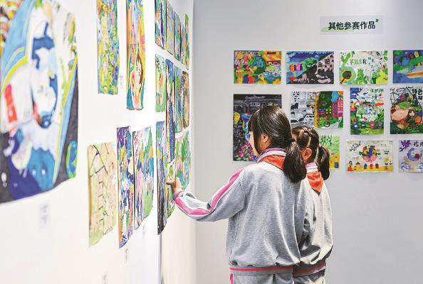             “双减”以来，中小学生课余艺体活动丰富多彩。图为孩子们在新天地的画廊参观环保作品展  本报记者  陶磊  摄          