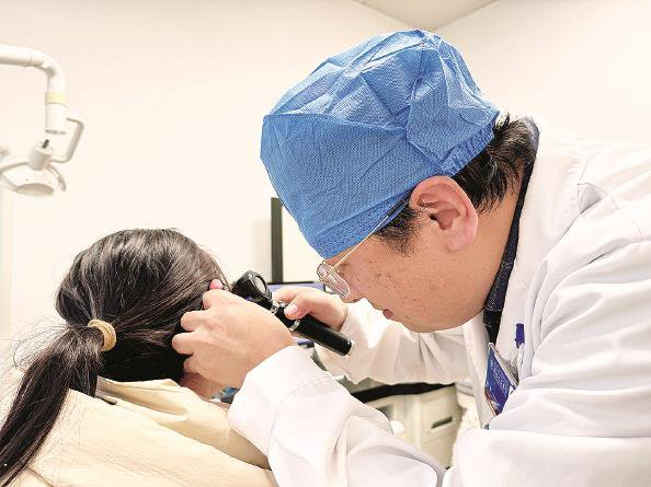             李蕴主任在给患者检查耳朵  左妍  摄          