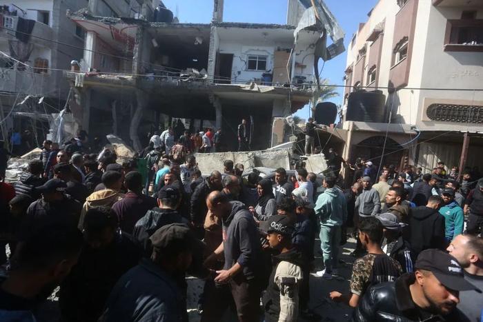▲2月24日，在加沙地带南部城市拉法，人们聚集在遭以军空袭的建筑前。新华社发（哈立德·奥马尔摄）