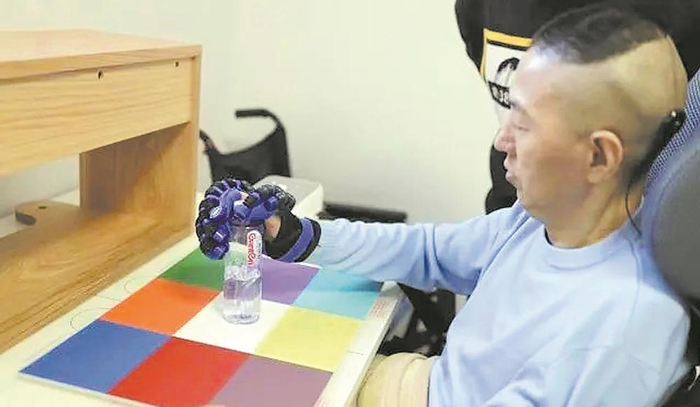     瘫痪患者在用脑机接口练习脑控抓握