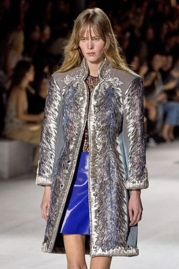 在一系列的全金色金属造型作为过渡后,一套套由刺绣装饰而成的外套