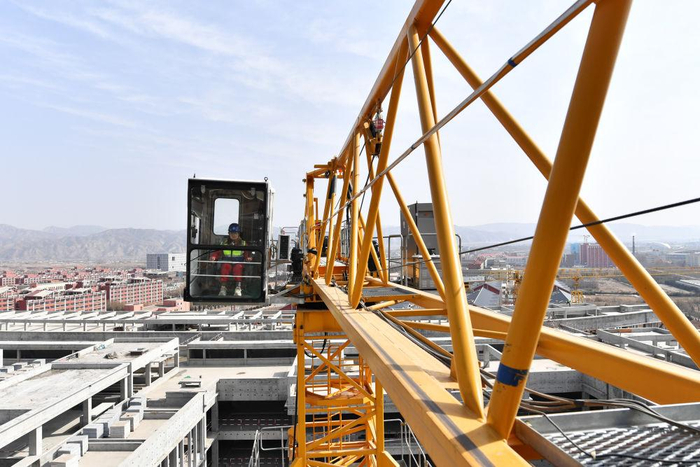 在中建三局兰州大学榆中校区项目建设工地,王甜甜(左)和搭档的信号工