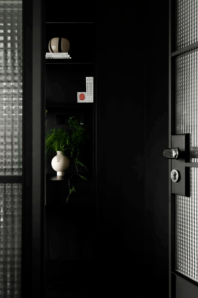 比起客厅的奶白色调,书房以几乎是浑然一体的全黑色调,材质选择上和