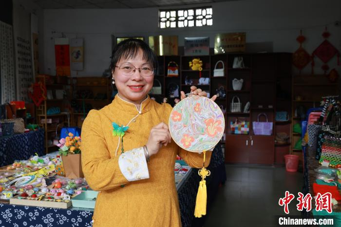 3月8日,广西柳州市"70后"非遗手作人黄丽红,身着旗袍演绎着水拓画技法