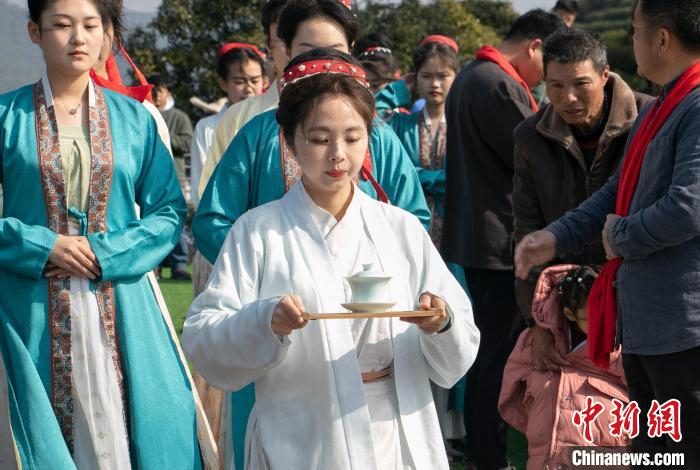 村里的茶农,"茶仙子"身着径山特色茶服,手捧果品敬山奉茶