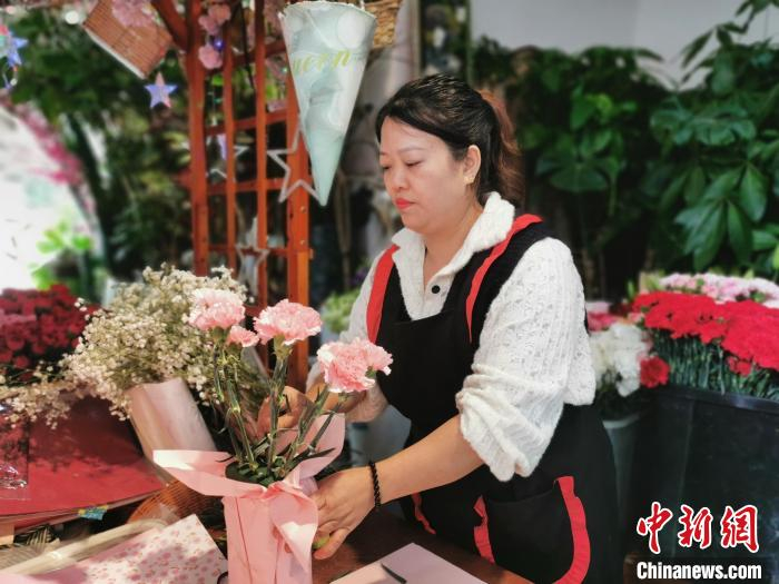 图为工作人员正在包扎鲜花.黄元荣 摄图为市民正在挑选鲜花.