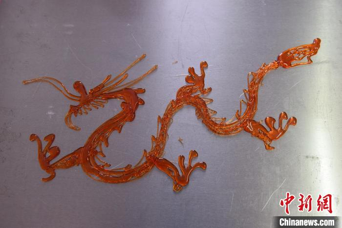 河北景县糖画艺人绘制龙形糖画感受舌尖上的非遗