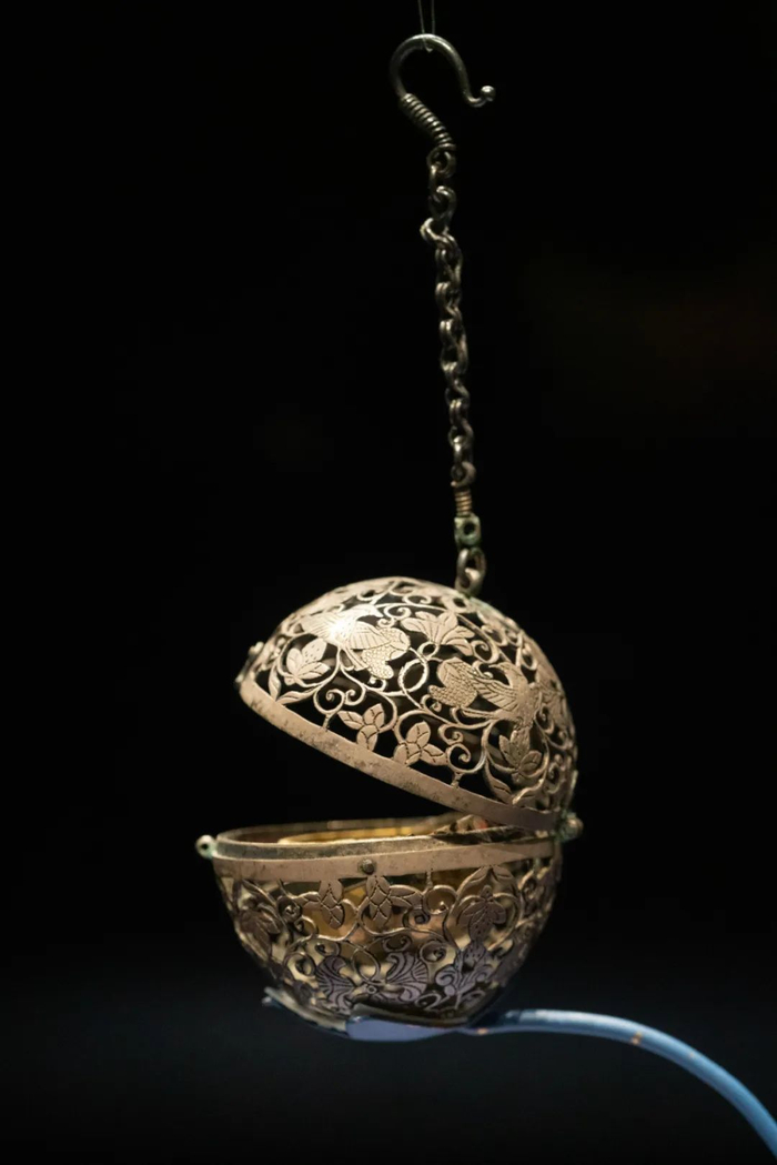 金筐宝钿团花纹金杯,杯口外侈,器壁有内向的弧度,"6"字形的把手铆钉在