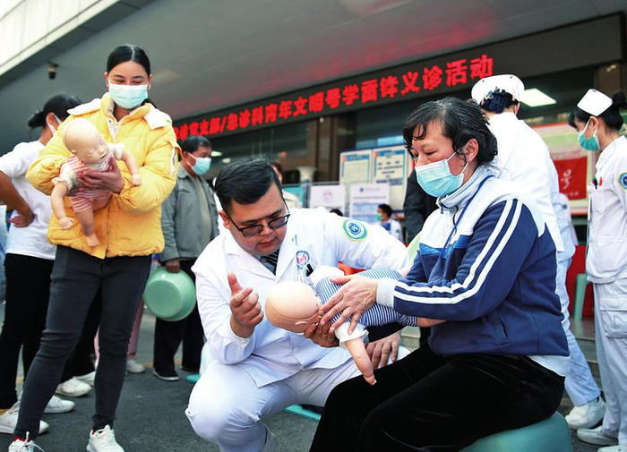 南宁市第二人民医院急诊党支部党员指导群众学习海姆立克法等常见急救知识。（王奇琦 摄）