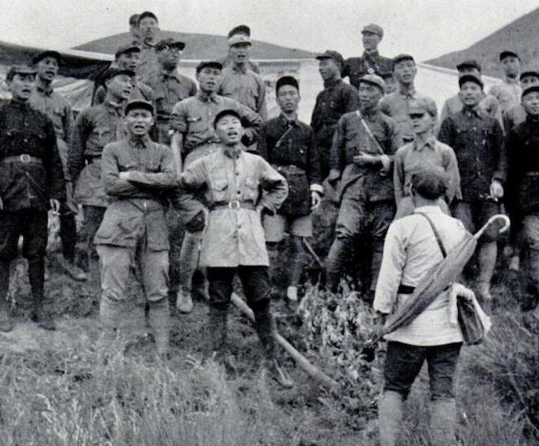 画面下方背着伞打拍子指挥者是彭加伦,唱歌人有刘亚楼,童小鹏,萧文玖