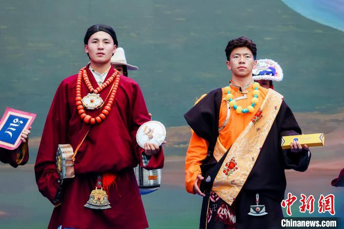 图为身着民族服饰的演员们展示果洛特产.