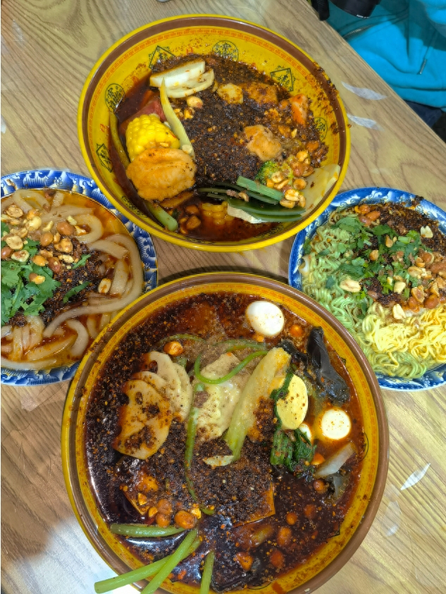 顾客选好菜品后递给老板,各式食材在滚烫的汤底中烫熟后捞出,加上原