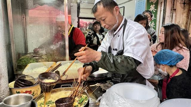 在天水市秦州区一处麻辣烫摊点上，工作人员正“左右开弓”地煮菜。新华社记者 文静 摄