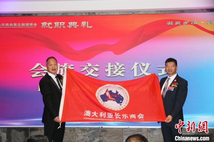 当晚的活动上,澳大利亚长乐商会第四届会长林秉阳(右)将商会会旗交接