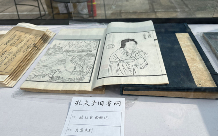 "来自孔夫子旧书网的赵爱军悉心向读者介绍了正在摊位中展出的古旧