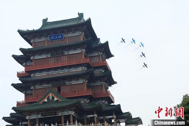 图为2023年10月25日上午，外籍飞行表演队“飞跃滕王阁”城市飞行表演，飞行编队拉烟飞过滕王阁。刘思伟 摄