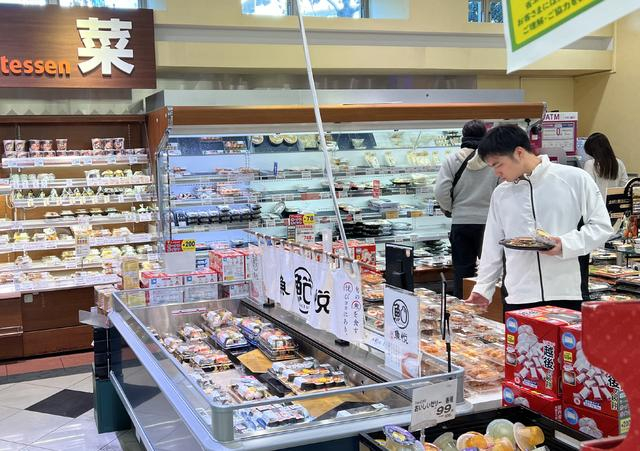 当地时间2023年12月22日,日本东京都港区,市民在超市选购食材.