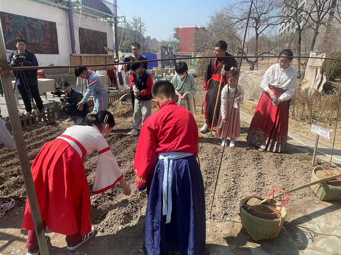 师生们来到小菜园，将小麦种子撒进土壤里。新京报记者 冯琪 摄
