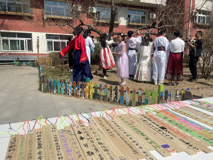 学生们将自己的春耕心愿和祝福写在木片上，挂在学校的树上。新京报记者 冯琪 摄