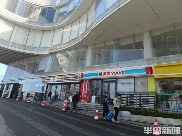 中联自由港湾大厦一楼，两家便利店紧靠在一起。