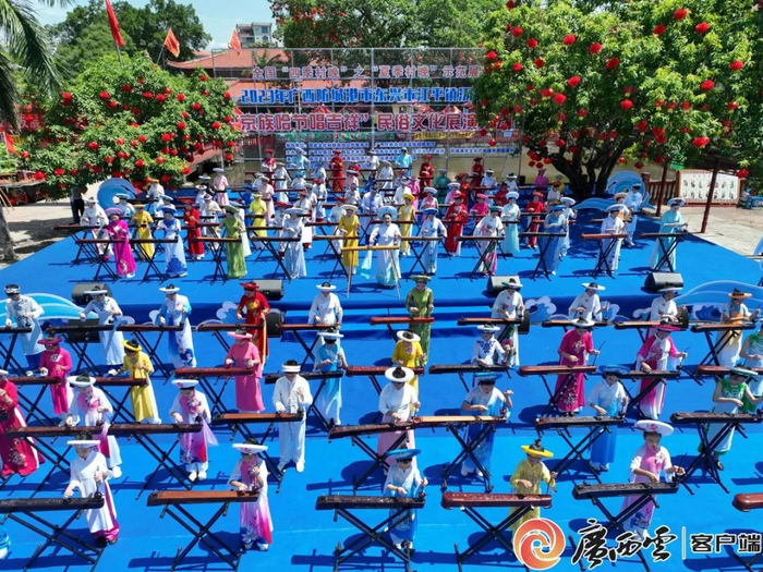 资料图：身穿特色民族服饰的京族“哈哥”“哈妹”在京族独弦琴艺术自治区级传承人苏海珍的带领下弹唱京族民歌《过桥风吹》。