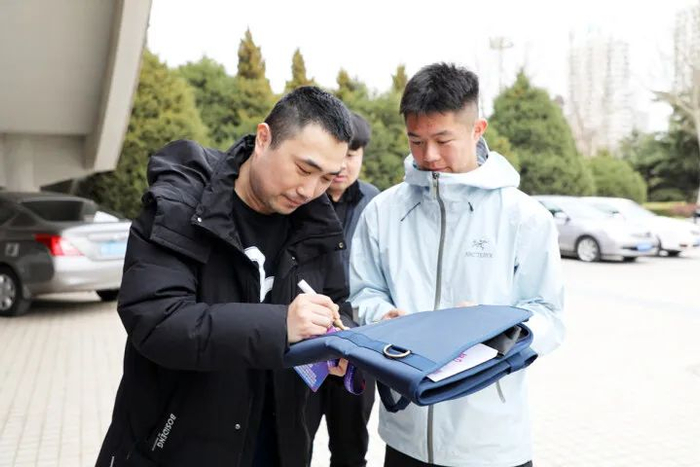 4月1日，苏新元在赛场外为粉丝签名。