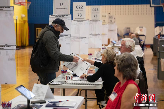 图为选民在纽约曼哈顿一处总统初选投票站领取选票.