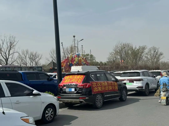 ▲来自周口的粉丝，在车上挂上了横幅。新京报记者 乔迟 摄